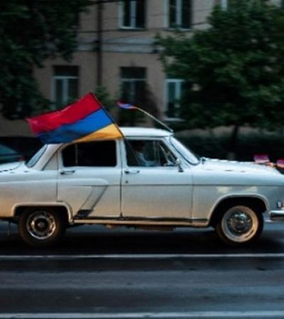 A white car with an Armenian flag