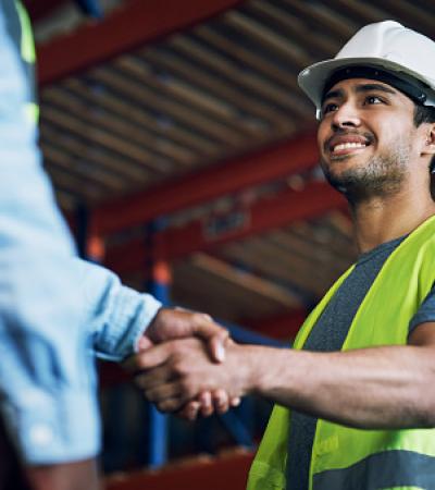 A man at a construction site greeting his colleague